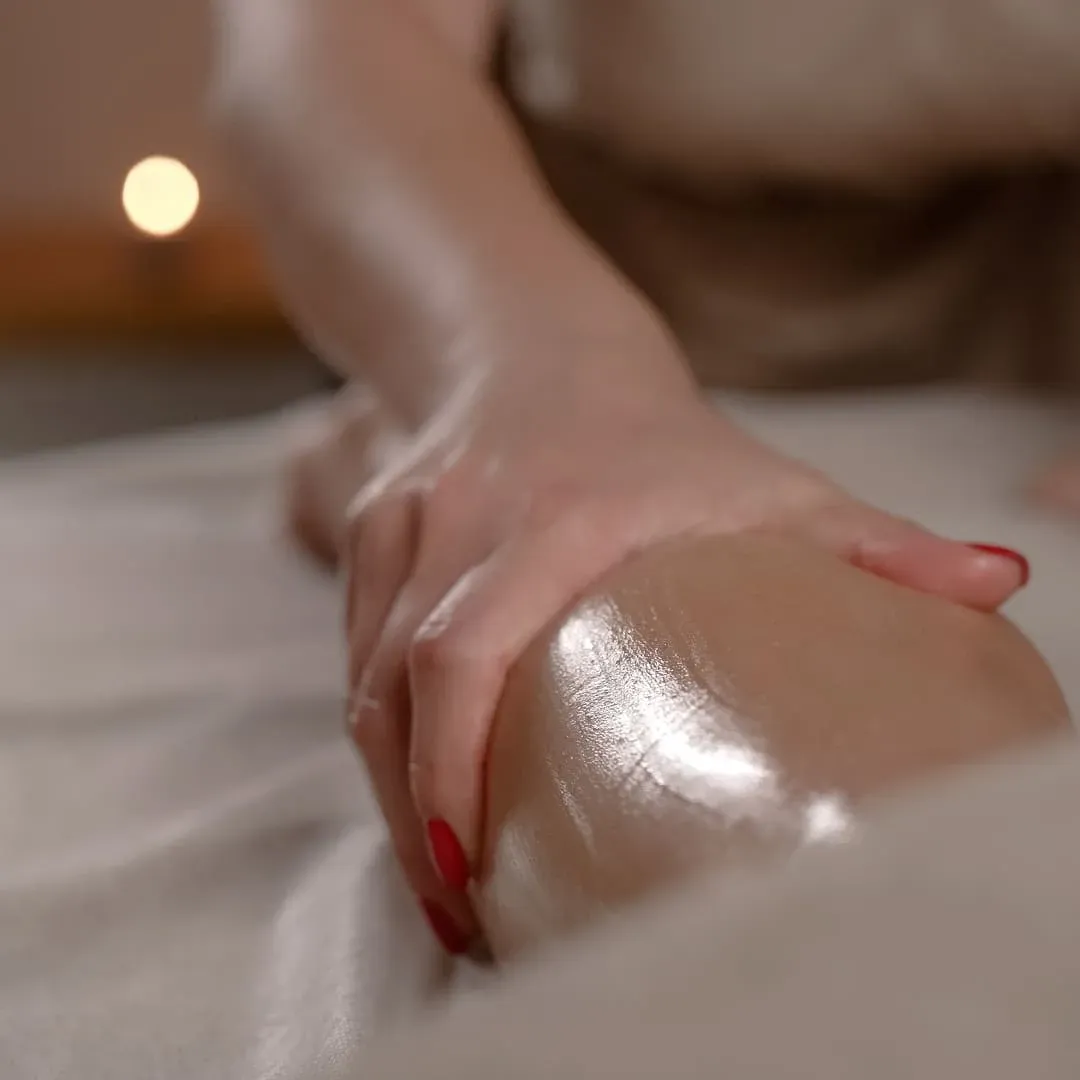 Oiled shoulder and upper arm under the therapist’s palm