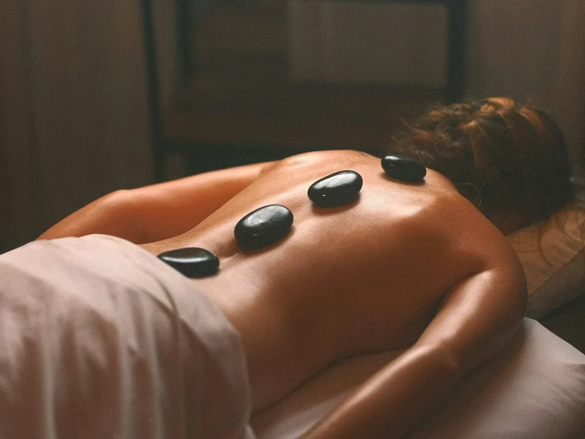 Smooth dark stones placed along a guest's back during a hot stone massage